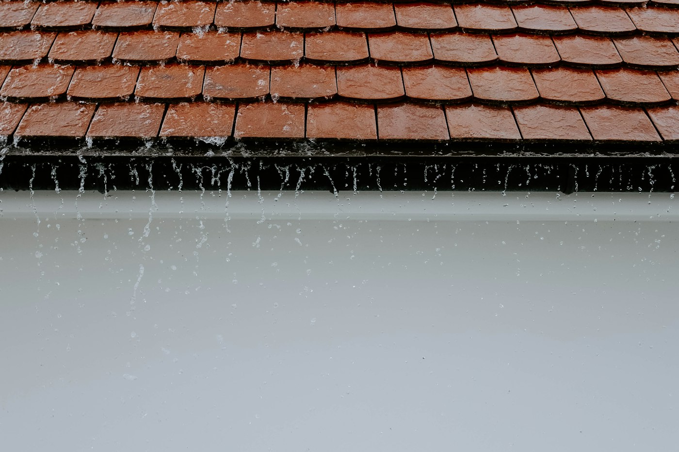 雨水顺着瓦屋顶的边往下淌